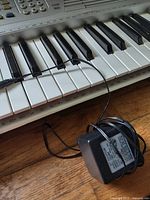 Keyboard segment with AC adapter resting on keys