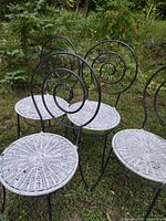Four iron chairs with wicker seats outdoors
