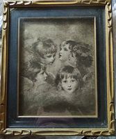 Framed black-and-white angel head print in gold carved frame