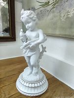 Full view of porcelain cherub figurine on base