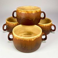 Group view of four matching drip-glaze handled bowls stacked