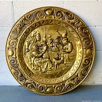 Full view of round brass tray with embossed medieval scene