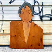 Front view of carved wooden male bust plaque