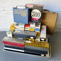 Stacked slides, two Opta-Vue cases, brown case, assorted slide boxes on tray