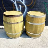 Two pale green wooden barrels used as side tables