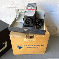 Projector in case on top of original box