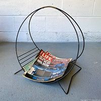 Front view of circular black metal magazine rack holding magazines