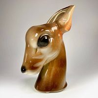 Front view of glazed ceramic deer head planter