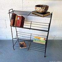 Three-quarter front view with sample books showing angled shelves