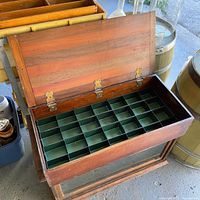 Open wooden box showing green metal compartment grid