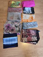 Top view of all ten scarves folded and laid out on floor