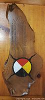 Full view showing live-edge burl cribbage board with painted medicine wheel and score holes