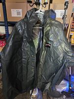 Full view of front of rain coat on hanger showing hood, snaps, zipper and Pioneer patch