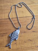 Full view of necklace with fish pendant on ball chain