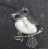 Front view of owl pendant showing white stone body and metal detailing