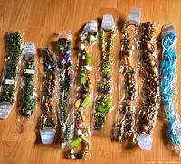 Nine packaged long necklaces laid out side by side