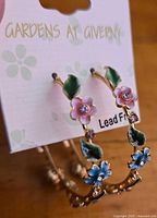 Front view of earrings on card shows floral design and brand name