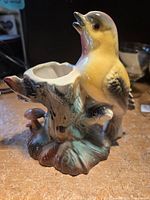 Front left view of glazed ceramic bird figurine showing hollow stump and mushroom