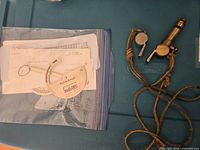 Overall view showing stylus gauge in plastic bag with cards and two whistles with lanyard