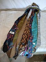 Group of fifteen assorted patterned neckties displayed on white surface