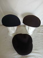 Front view showing two hats on stands and one laid flat