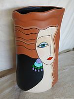 Front view of ceramic vase showing stylized female portrait