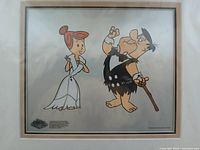 Close view of framed print showing Fred and Wilma Flintstone