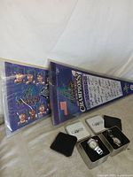 All items laid out: two posters, two watch tins with watches