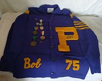 Full view of letterman sweater showing patches, medals, buttons