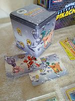 Grey Clefairy cube tin with two art inserts visible