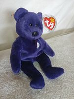 Full view of purple Ty Princess Diana bear seated with swing tag