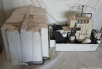 Entire lot showing Singer serger in base of white carry case and damaged case lid