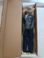 Full view of doll inside cardboard box