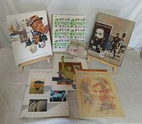 All six USPS commemorative stamp books on display with bag of loose stamps