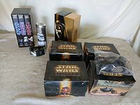 Full lot overview showing VHS sets, Episode I boxes, tin, watch and accessory bags