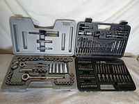 Both tool sets open: Craftsman socket set left, drill/driver bit set right