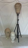 Tripod stand with three mannequin heads displayed