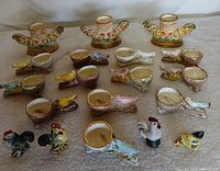 All 19 ceramic pieces laid out: 2 turkey holders, 15 bird cups, 2 roosters