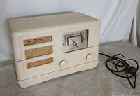 front view of cream Wards Airline radio showing dial, knobs, grille and cord
