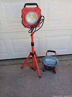 Tripod LED work light on stand and floor LED work light side by side