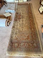 Full length view of rug laid flat showing pattern and fringe