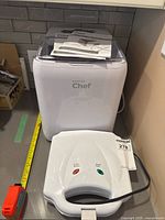 Ice maker and sandwich maker on counter with manual visible