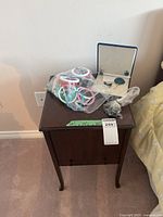 Wooden stand with bagged jewelry and blue jewelry box on top