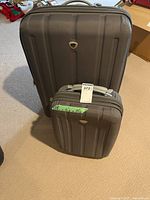 Front view of both grey hard-shell suitcases