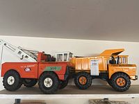 Both Tonka trucks side by side on shelf