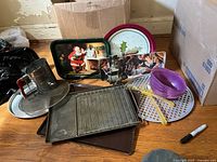 Group shot showing Coca-Cola tray, art tray, baking pans, flour sifter, wire rack, perforated tray, purple bowls, utensils