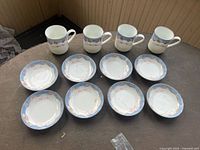 Full set of 4 mugs and 8 plates displayed on table