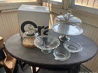 Group shot of all five serving pieces including large cake stand with dome, small dome with cork base, compote bowl, and two small bowls