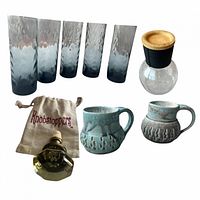 Group shot of all nine pieces showing tumblers, carafe, mugs, stopper and pouch