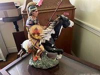 Left profile view of warrior on horse showing shield, spear, and broken horse tail